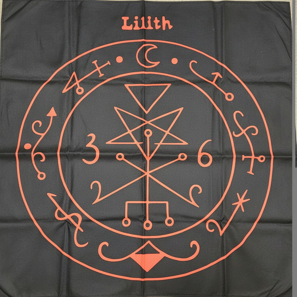 Decorative red symbol on a black fabric background