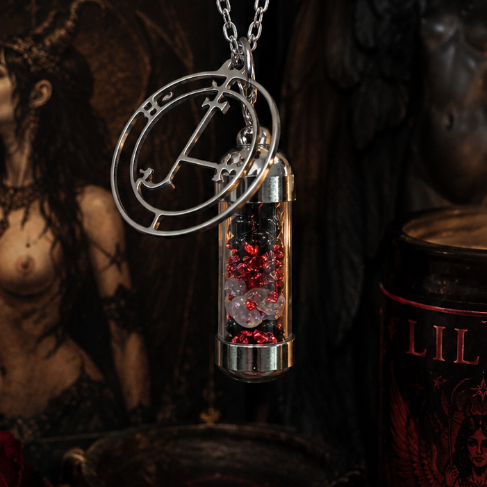 Necklace with a pendant featuring red stones next to a 'LILITH' candle and dark background.