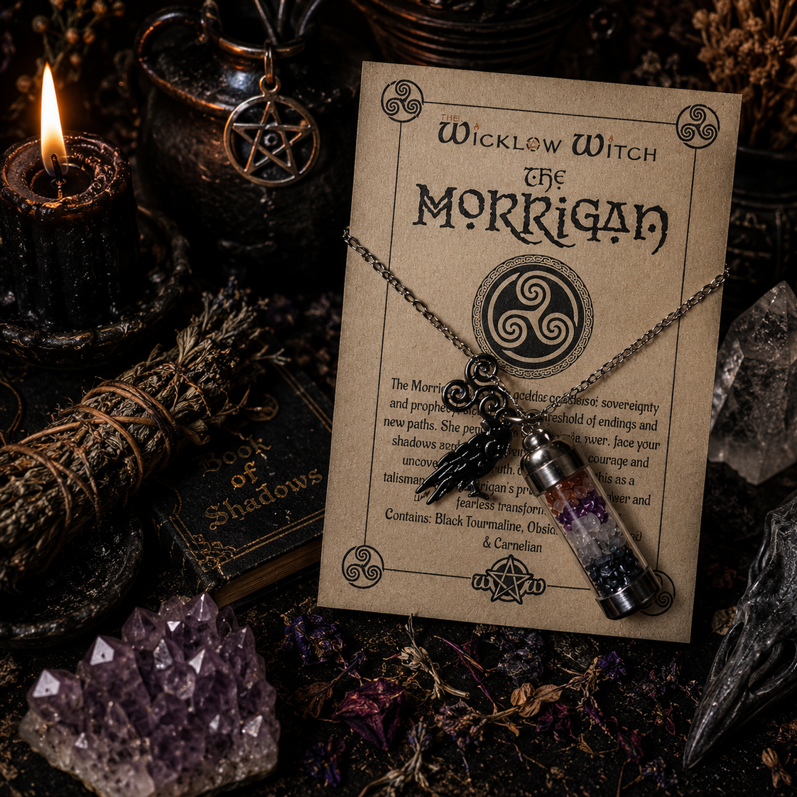 Necklace with pendant on a 'Wicklow Witch The Morrigan' card surrounded by mystical items.
