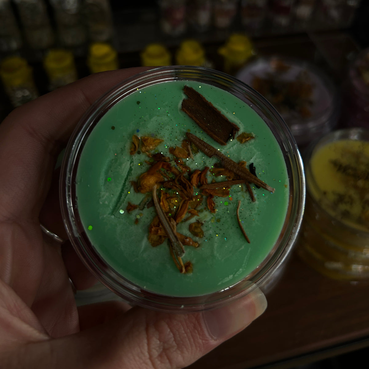 Green prosperity wax melt topped with botanicals