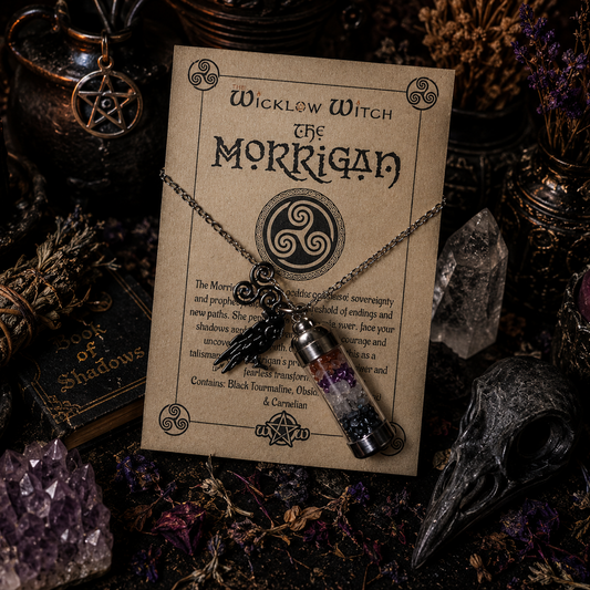 Necklace with pendant on a 'Wicklow Witch The Morrigan' card surrounded by mystical items.